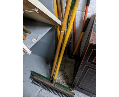 A selection of wooden handled garden tools to include garden rakes, spade, forks, and other tools Location: 