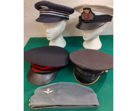 A collection of services hats to include a London Underground peaked cap, a Royal UK Merchant Navy officer white and black pe
