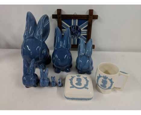 A collection of seven blue Denby models of seated rabbits, all of various sizes, a Delft blue and white Royal London plaque, 