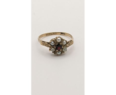 A 9ct gold ring set with a red garnet and pearls, 2.4gLocation: 