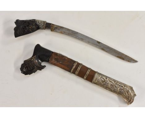 An Indonesian silver mounted kris or parang type dagger, 16cm curved blade, horn grip carved with flowers and scrolling folia