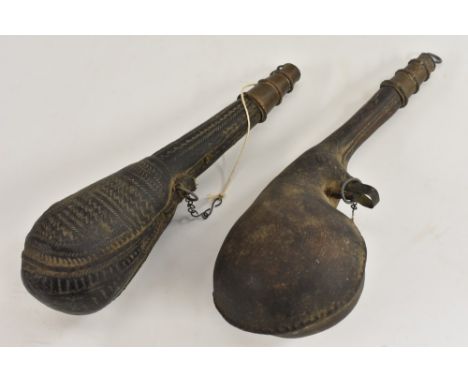 A Middle Eastern cuir bouilli camel scrotum powder flask, tooled overall, 26.5cm long overall, 19th/early 20th century; anoth