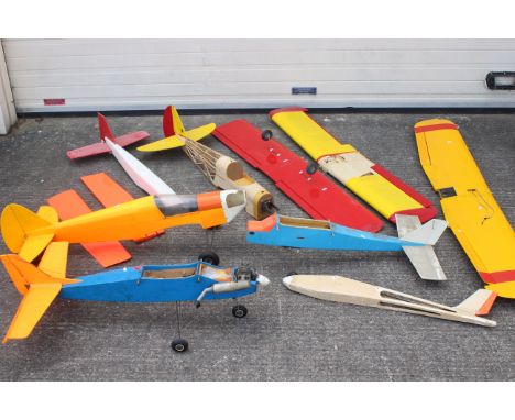 A mixed lot of scratch built remote control airplanes and parts and control surfaces with one engine of unknown manufacture. 