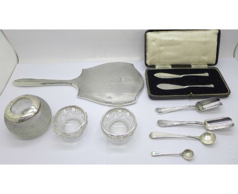 A silver hand mirror, a silver mounted match strike, a pair of silver butter knives, cased, two silver caddy spoons, etc. 