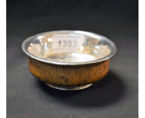 A Tibetan silver-mounted indigenous timber circular libation bowl, raised foot ring, 10cm diam 