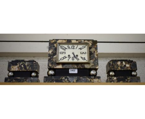 An Art Deco marble and steel clock garniture, rectangular dial, shaped Arabic numerals, chiming movement, block and ball colu