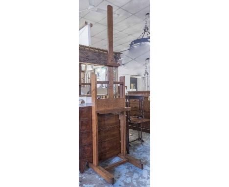 EASEL, early 20th century adjustable oak with winding action on castors, approx 273cm H fully extended, 60cm x 65cm.