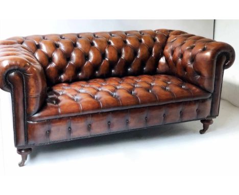 CHESTERFIELD SOFA,Victorian style hand finished leaf brown leather with curved deep buttoned back, arms and seat on turned fr