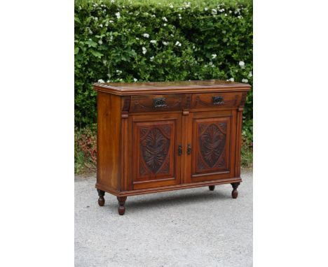A late Victorian mahogany chiffonier, circa 1890, comprising two short drawers over two cupboard doors, machine carved panels