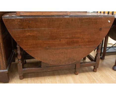 A late 17th Century early 18th Century oak gate leg table, plank top, two drop down leaves, turned legs, with end cutlery dra