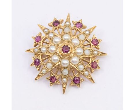 A Victorian ruby and seed pearl 9ct gold star brooch, the centre set with a round cut ruby within a circular border of half p