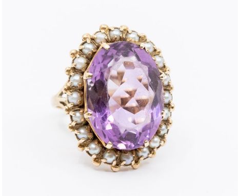 An antique amethyst and pearl set 9ct ring, oval amethyst within a border of half pearls setting approx. 20mm x 25mm, size Q,