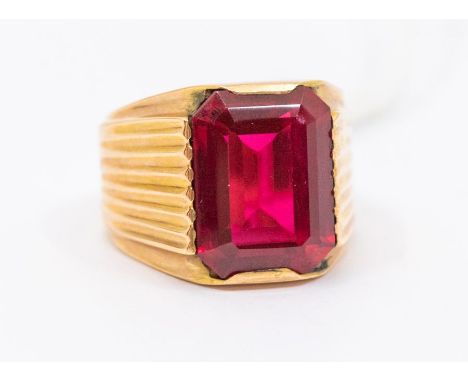 A synthetic ruby and rose metal dress ring, comprising a rub over set emerald cut synthetic ruby, measuring approx. 12 x 15mm