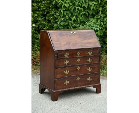 A George III style mahogany bureau, the fall front opening to reveal a fitted interior, the front with four long graduated dr