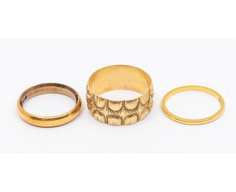 Two 22ct gold bands, size K and L, weight approx. 6.6gms along with a wide 9ct gold band heavily embossed decoration, size P,