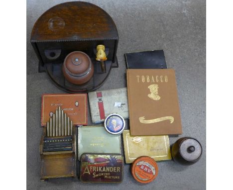 A tobacco box with pottery jar and pipe, a cigarette dispenser in the form of an organ, John Player book and tins