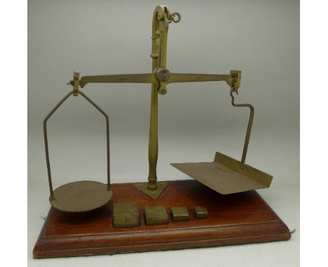 A set of postal scales on a wooden base with four square weights marked GPO