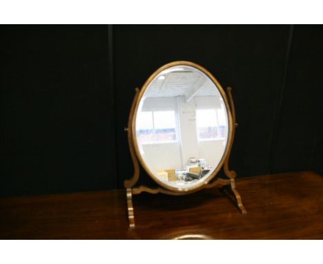 EDWARDIAN MIRROR - an Edwardian bevel edged oval toilet mirror in fruitwood. Measures 56x45cm.