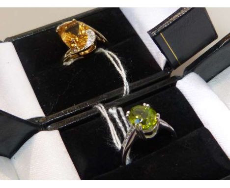 Peridot and silver ring, size N; and a citrine and diamond ring, hallmarked 9ct gold, size N (2)