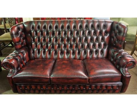 A Chesterfield Ox Blood Hide Three Seater Sofa, Having a high wing back, 91cm high, 191cm wide