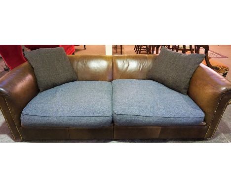 A Tan Leather Three Seater Chesterfield Sofa, with fabric covered seats and cushions, 70cm high, 240cm wide, 115cm deep