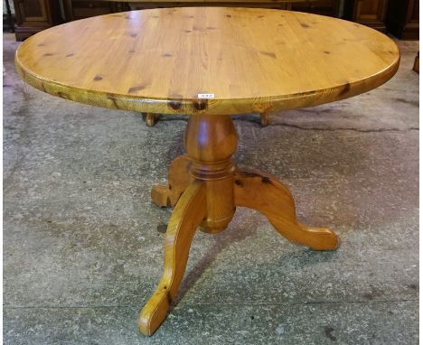 A Pine Kitchen Table, with a circular top, raised on a turned column and tripod legs, 77cm high, 105cm wide