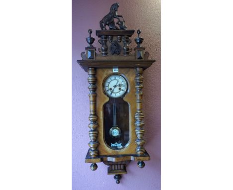 A Walnut Cased Vienna Wall Clock, circa early 20th century, with a horse and figure surmount to the top, above a glazed door 