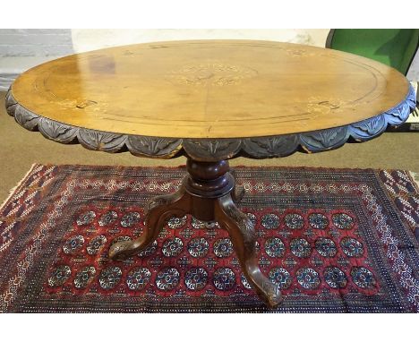 A Victorian Walnut Loo Table, Decorated with inlaid floral panels to the oval top, raised on a turned column and carved tripo