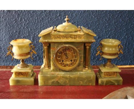 A green onyx clock garniture with brass dial and frieze with a Greek scene matching that of the vases, stricking on a coiled 