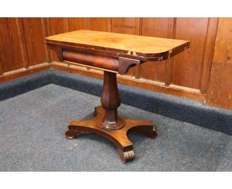 A William IV mahogany card table with fold-over top raised on a octagonal tapering baluster column termintaing on platform ba
