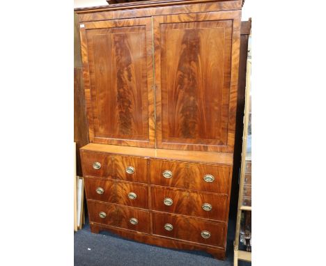 A Georgian mahogany cabinet secretaire, the mouled cornice above a pair of panel cupboard doors over secretaire frieze drawer