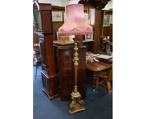 A carved giltwood standard lamp with pink shade, 162cm to top of brass fitting. #83 