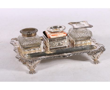 White metal desk stand, with three inkwell holders and double sided pen wells, raised on lion paw feet, 650g, 24cm long. 