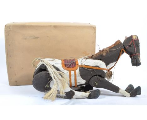 An early 20th century carved wood horse string puppet. Having painted body with leather strap detailing. Measures approx. 44c
