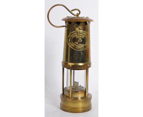A vintage 'E Thomas & Williams Ltd, Makers, Aberdare, Wales', brass paraffin oil lamp with hanging hook. The brass name plate