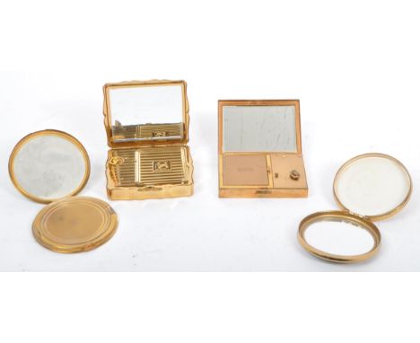 An assortment of four vintage 20th century ladies compacts to include a Swiss Abme musical example with empty floral cartouch