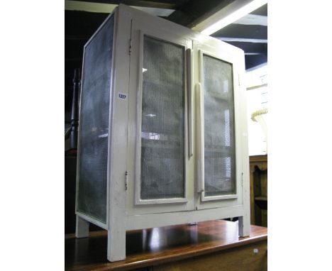 A vintage painted pine framed floor standing meat safe enclosed by a pair of doors with mesh panels