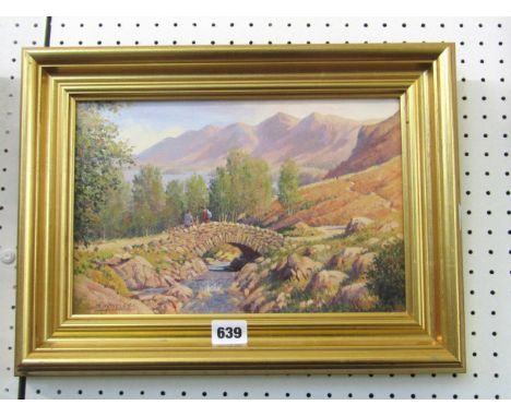 A 20th century oil painting on canvas of a mountainous landscape with two figures sitting on a single arched stone bridge, si