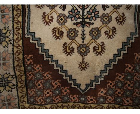 A wool carpet with white ground medallion upon a mid brown field within alternating borders and geometric detail, 280cm x 160