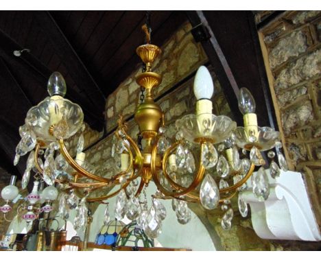 A brass eight branch chandelier with cut glass drops and drip trays 