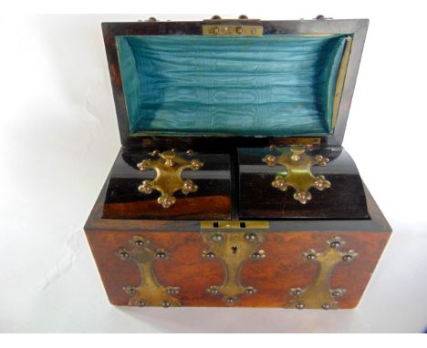 A Victorian figured walnut tea caddy of casket form, the domed lid with applied brass strap work detail, the interior with tw
