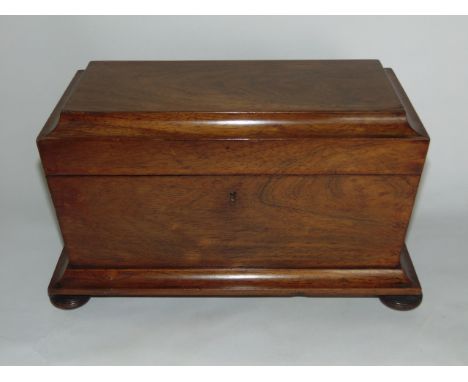 A regency mahogany sarcophagus shaped tea caddy with ring handles and fitted interior