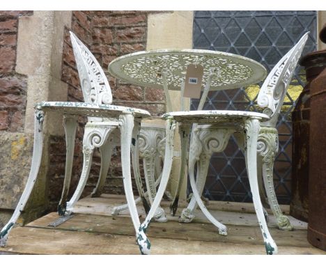 A Victorian style cast aluminium garden terrace table with decorative pierced circular top raised on swept tripod supports to