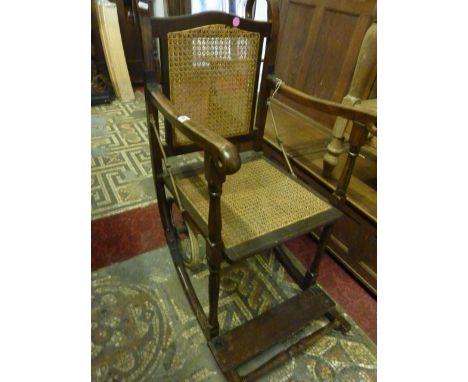 A vintage invalid chair, the stained beechwood frame with crook handles and cane seat and back