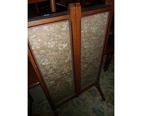 A mid Victorian oak and ebonised fire screen in three panels, the central panel with original hand worked tapestry showing a 