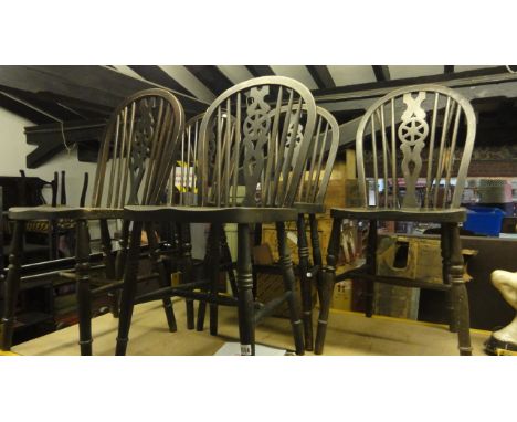 A set of five stained elm and beechwood Windsor hoop and stick back kitchen chairs with central pierced wheel splats over sad