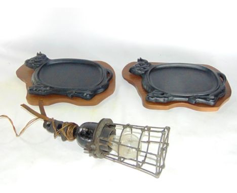 A vintage steel inspection light with two cast iron steak plates in the form of oxen on timber bases