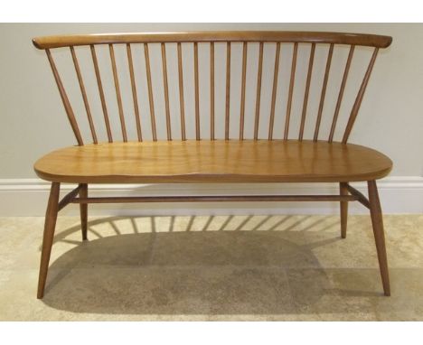 An Ercol elm and beechwood love seat on turned supports and stretchers with light finish