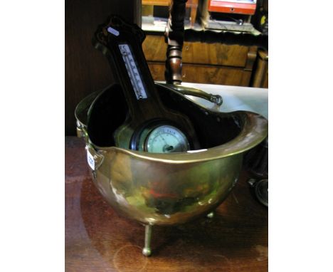 A planished brass helmet shaped coal scuttle with loop handle raised on three splayed legs, in the Arts & Crafts style, toget