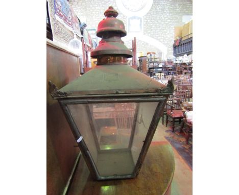 A Victorian copper framed street lantern of square tapered form with glazed panels and raised finial, canopy bearing label, W